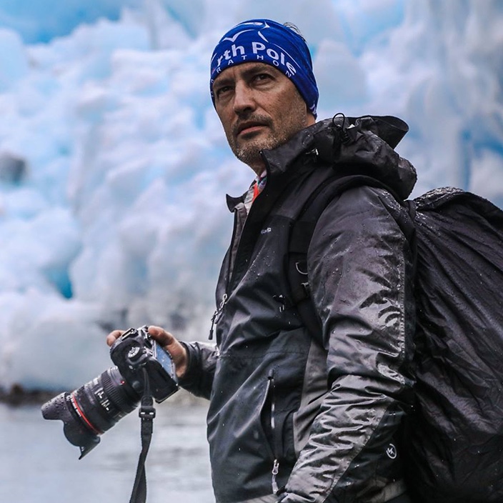 Rodolfo Soto con su cámara frente a un glaciar